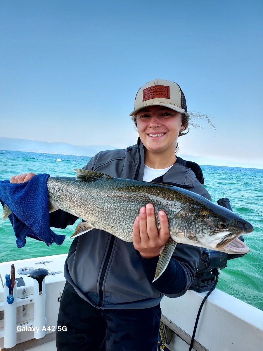 A woman is holding a large fish on a boat.