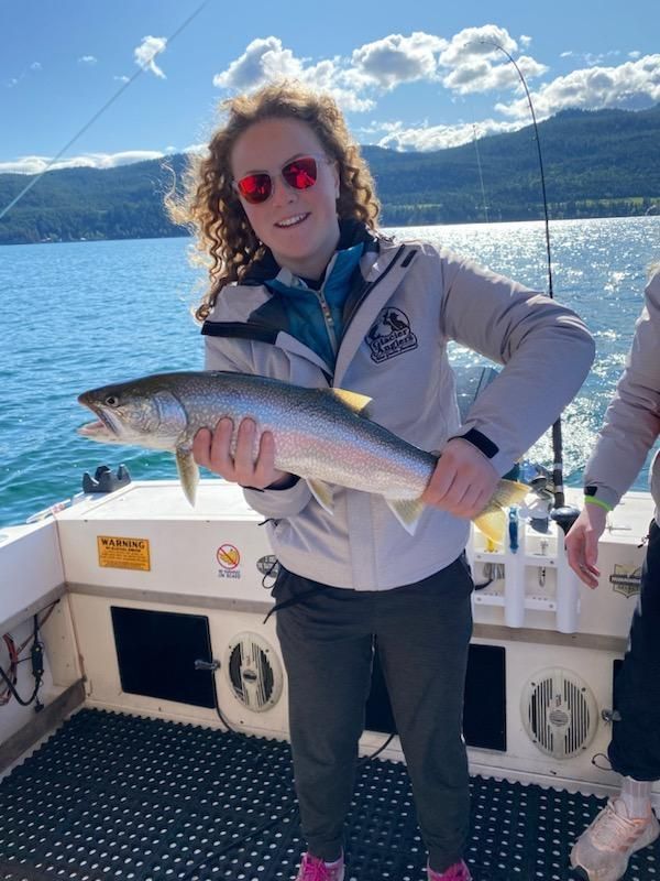 A woman is holding a fish in her hands on a boat