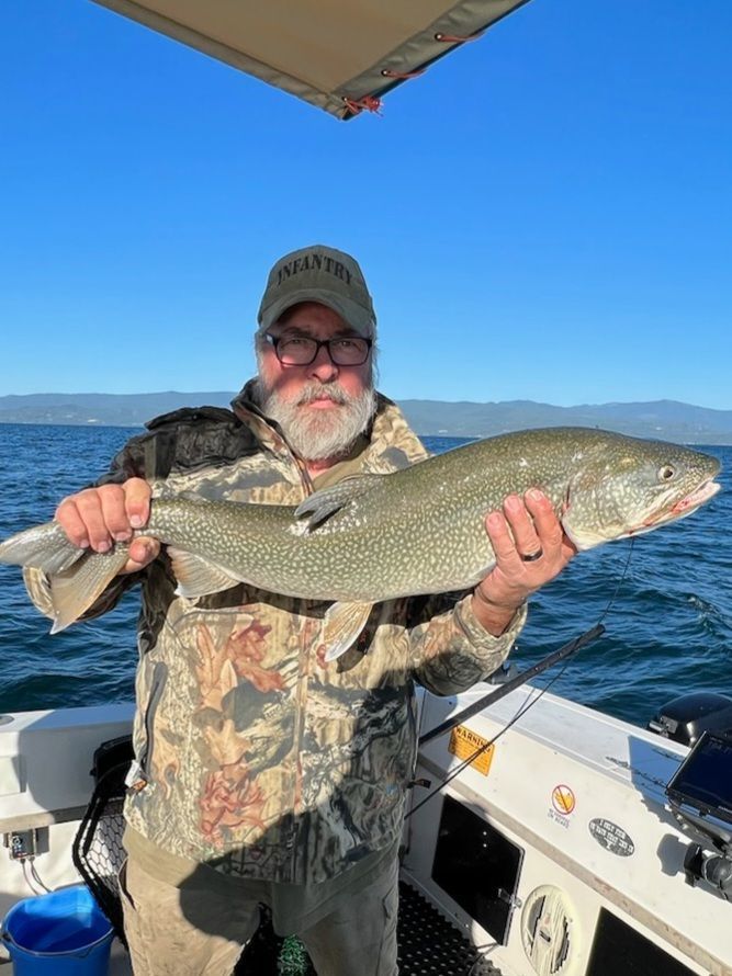 A man is holding a large fish on a boat.