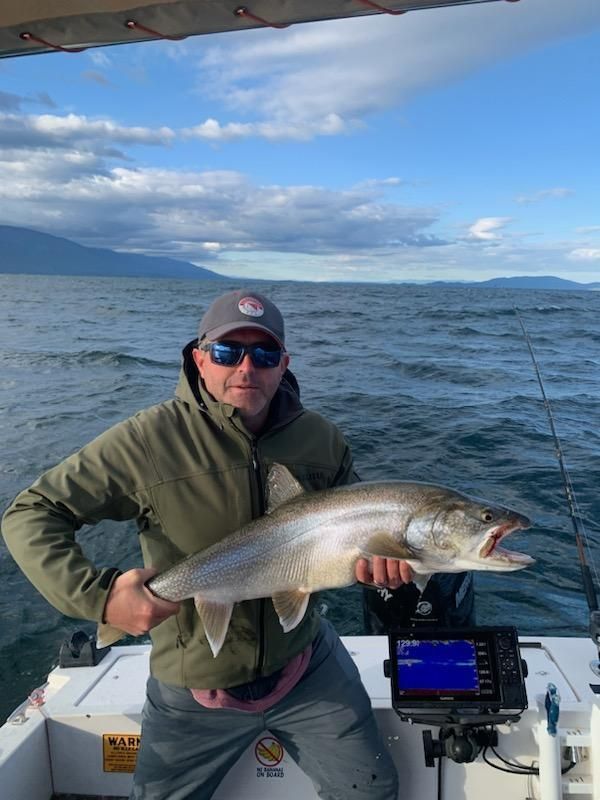 A man is holding a large fish on a boat.