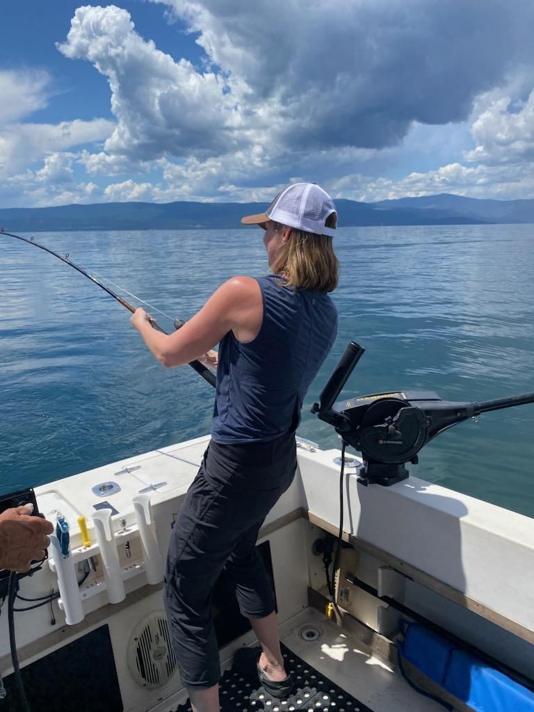 A woman is fishing on a boat in the ocean.