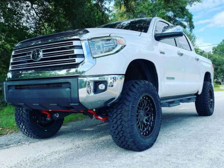 A white toyota tundra is parked on the side of the road.