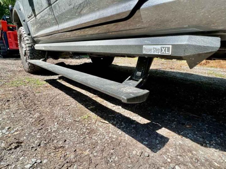 A close up of a truck 's side step on a dirt road.