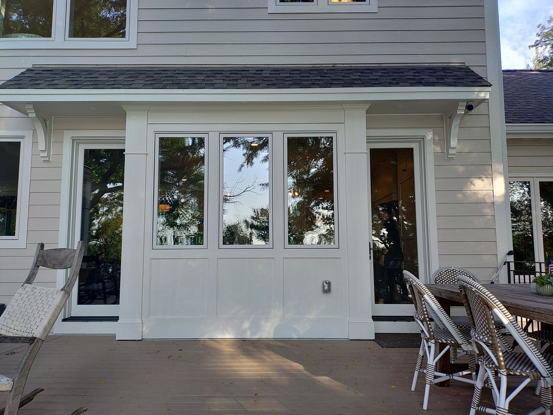 Back patio with white framed windows and doors on a wood deck.