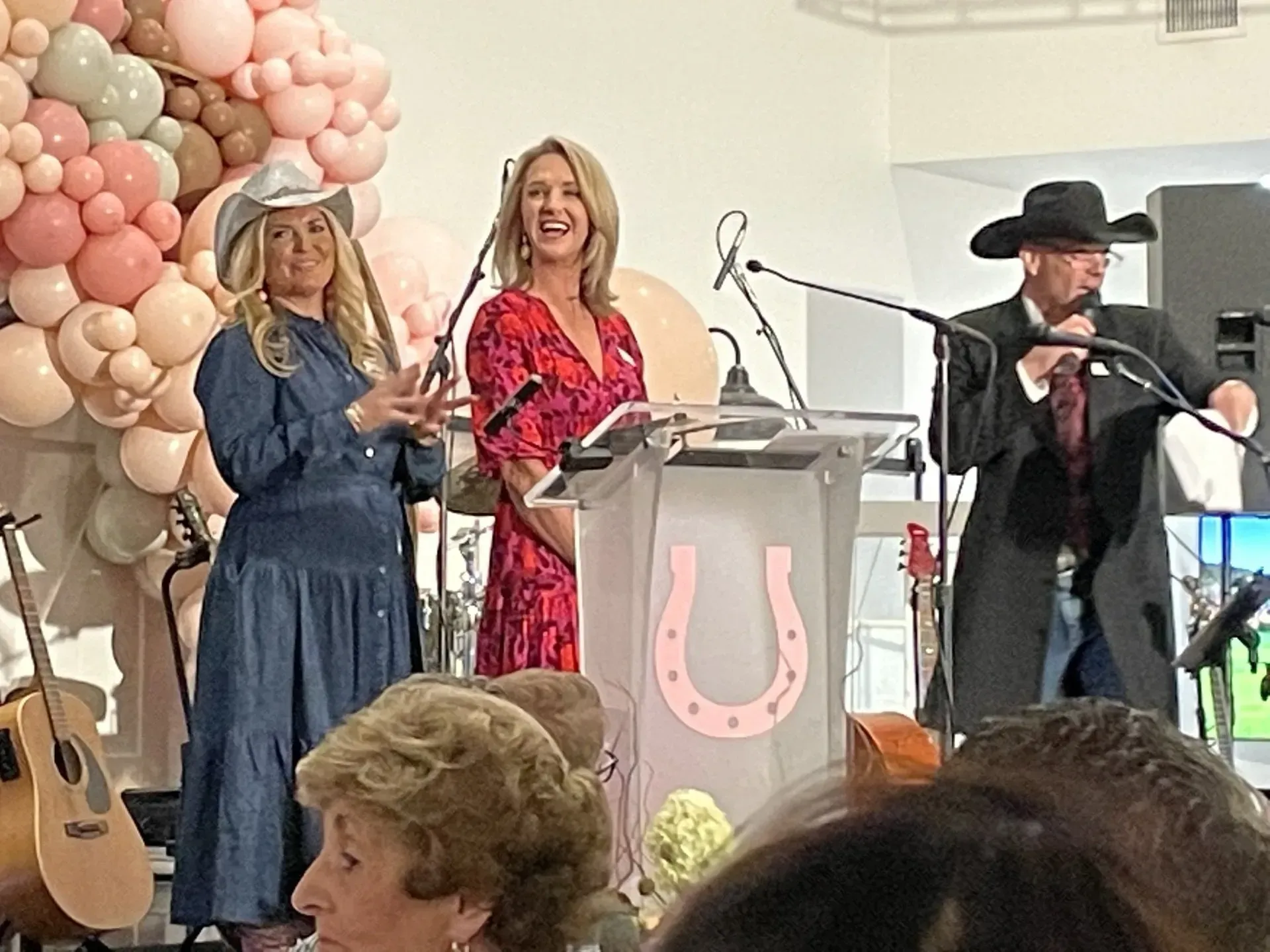 a group of people are standing around a podium with a horseshoe on it