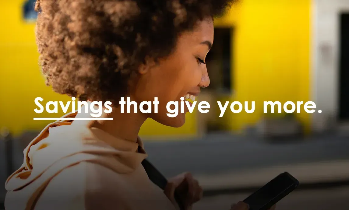 a woman is smiling while looking at her cell phone