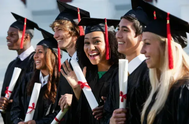 a group of graduates are smiling and holding their diplomas