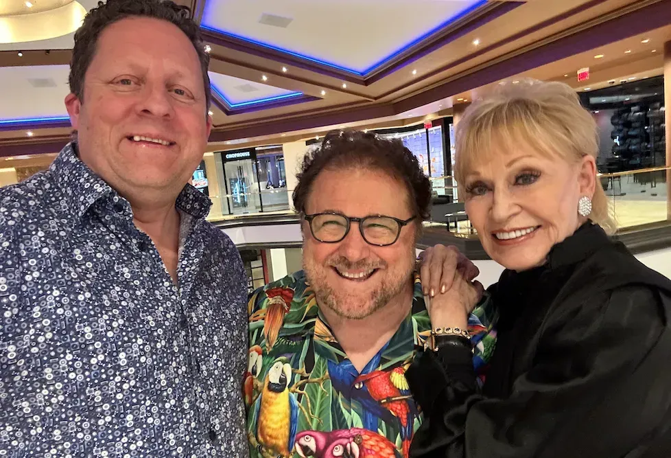 a man and two women are posing for a picture in a room .