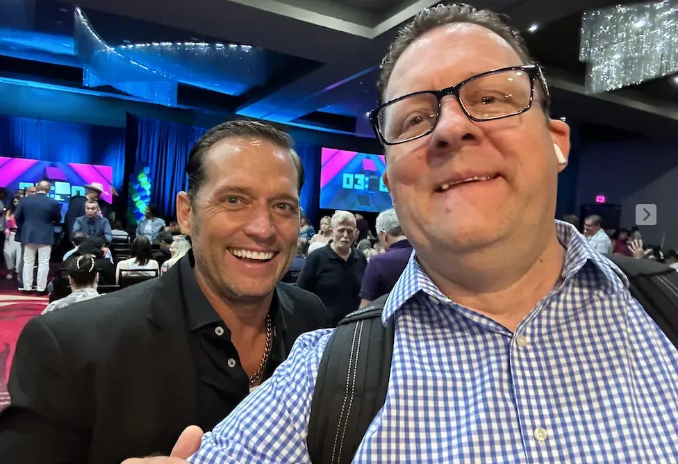 two men are posing for a picture together in a room