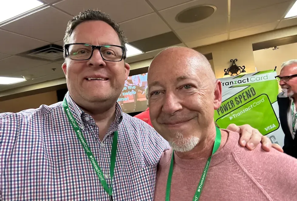 two men are posing for a picture together in a room