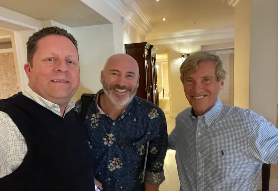 three men are posing for a picture together in a hallway