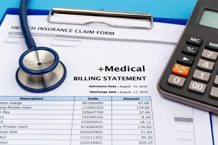 a stethoscope is sitting on top of a health insurance claim form next to a calculator .