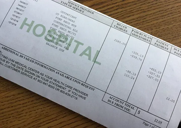 a hospital bill is laying on a wooden table