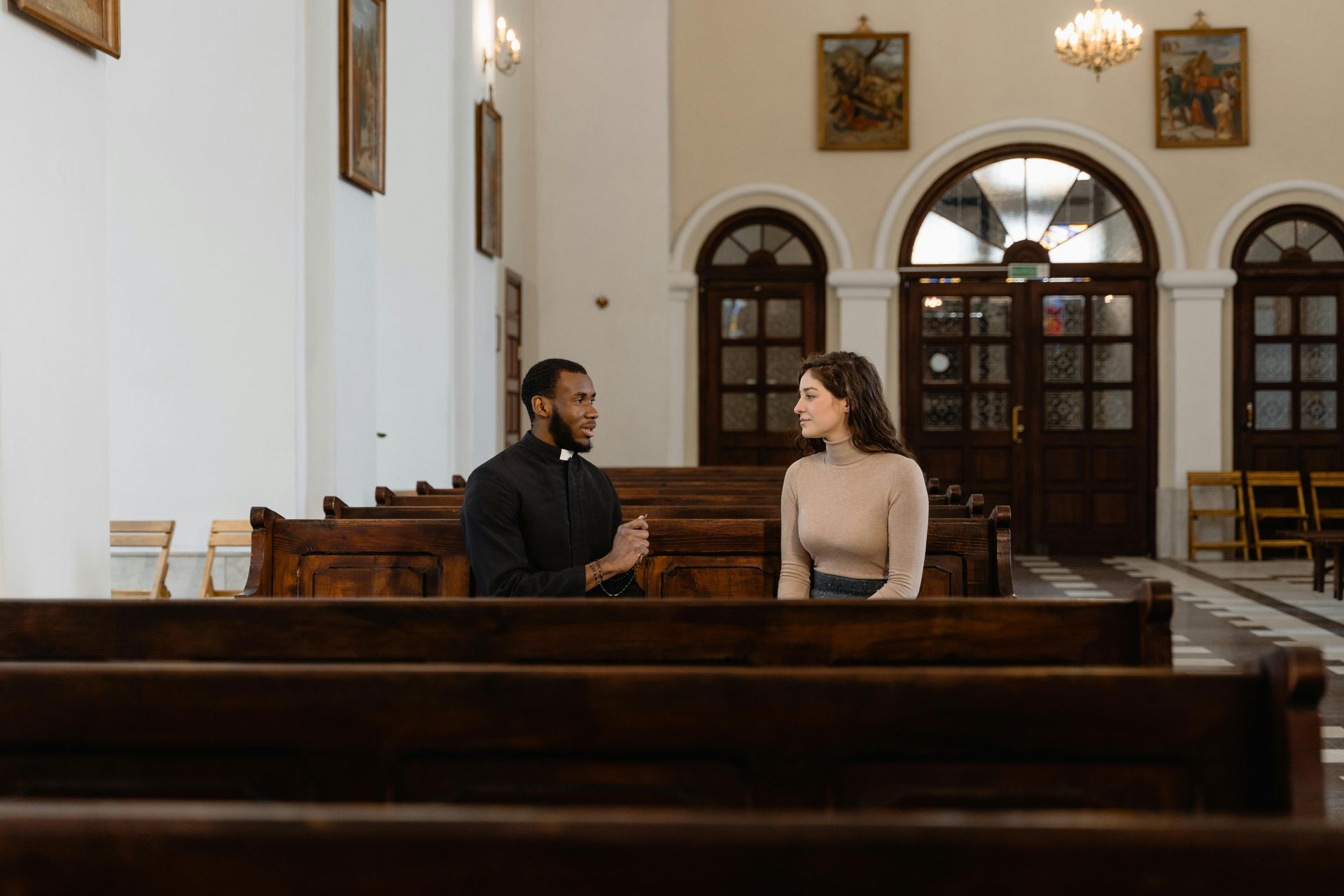Woman speaking with spiritual counselor in peaceful church setting