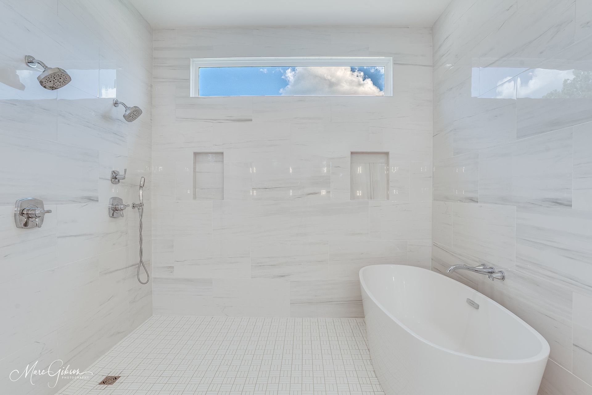 Modern white bathroom with large shower, soaking tub, and window with a sky view.