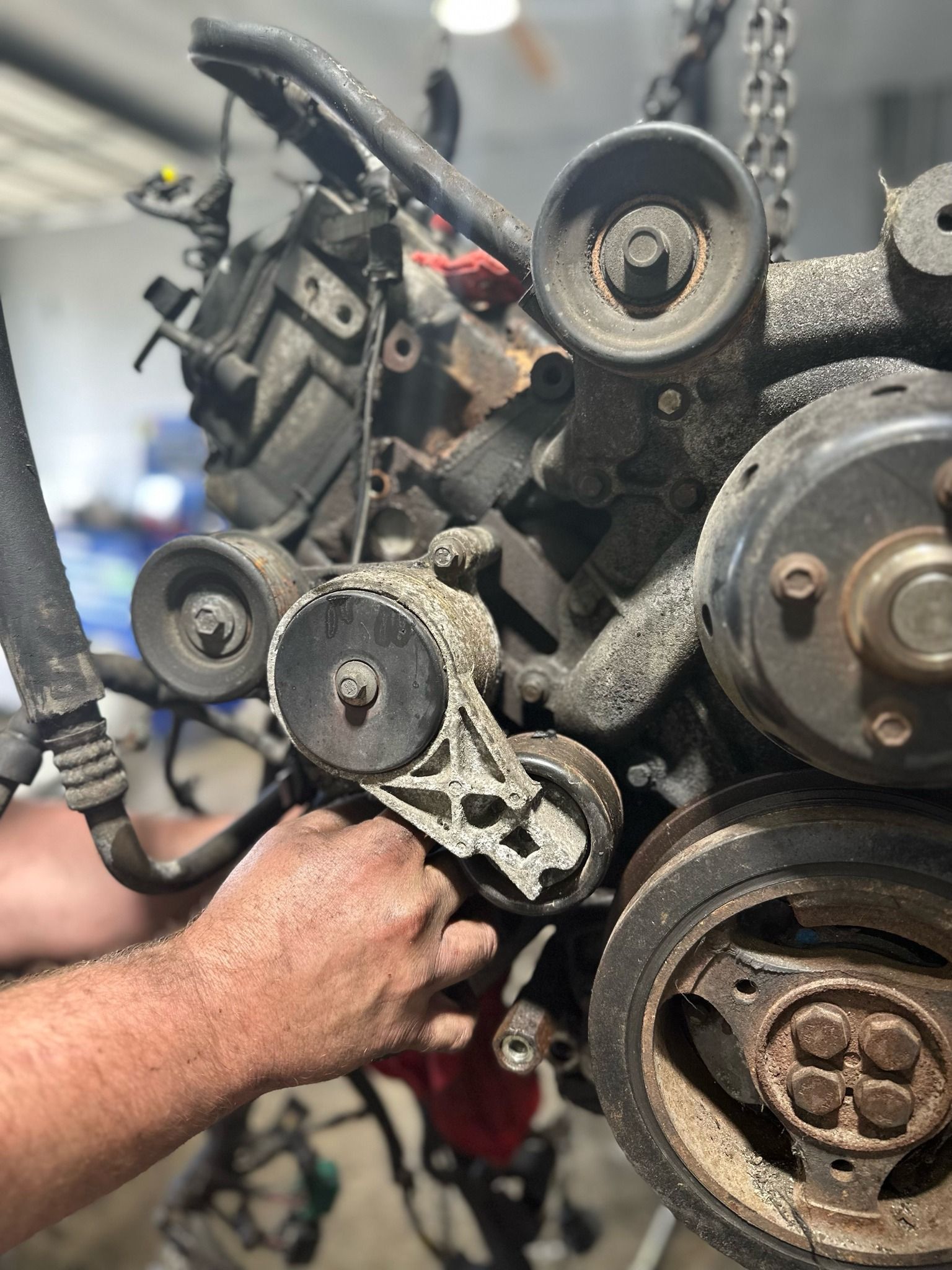 A man is working on a car engine in a garage.