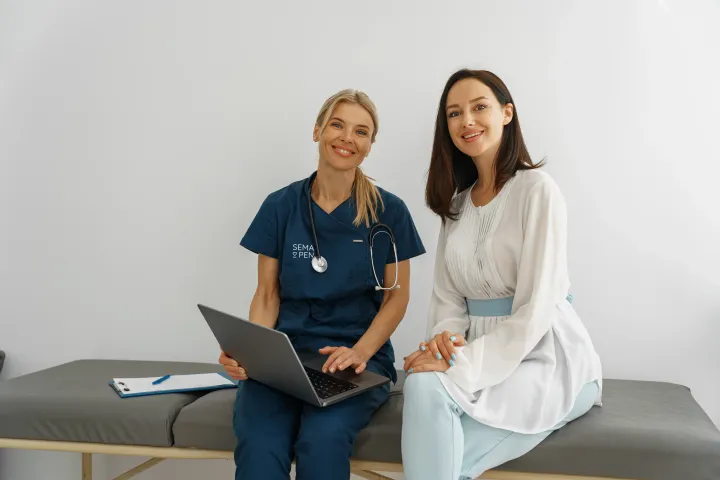 A medical professional in a SemaPen uniform sits next to a consultant.