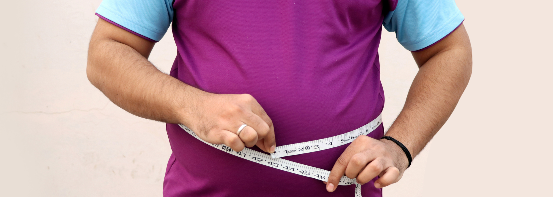 Picture of a person with central adiposity with a tape measure around their waist.