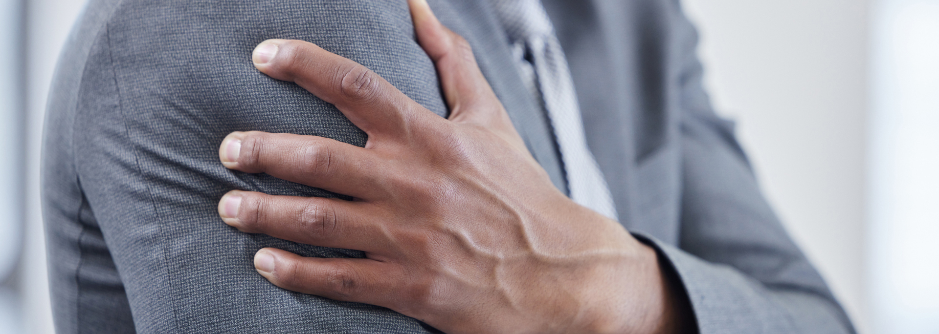 Picture of a person holding their arm in pain. Picture of a person holding their arm in pain.