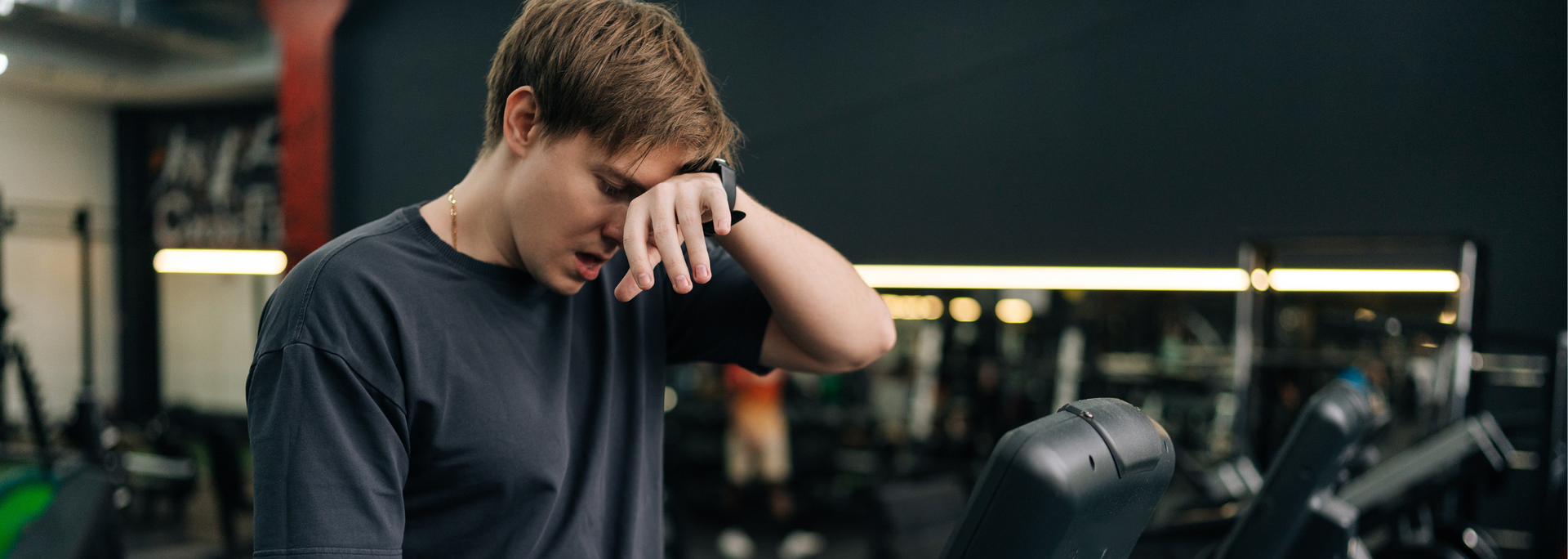 Picture of a person looking tired at a gym. 