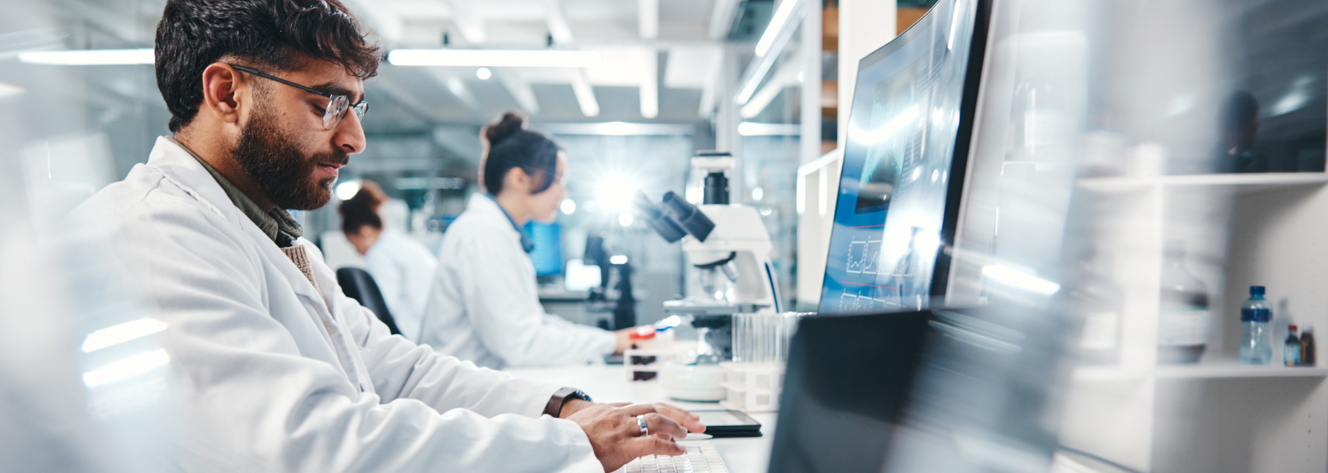 Picture of a scientist working at a computer in a lab. Picture of a scientist working at a computer in a lab.