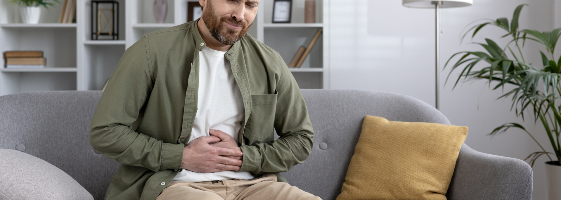 Picture of a man clutching their stomach in mild discomfort. Picture of a man clutching their stomach in mild discomfort.