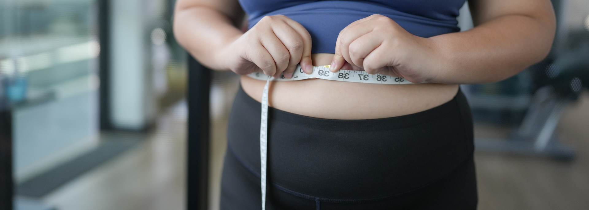 Picture of someone measuring their waist. 