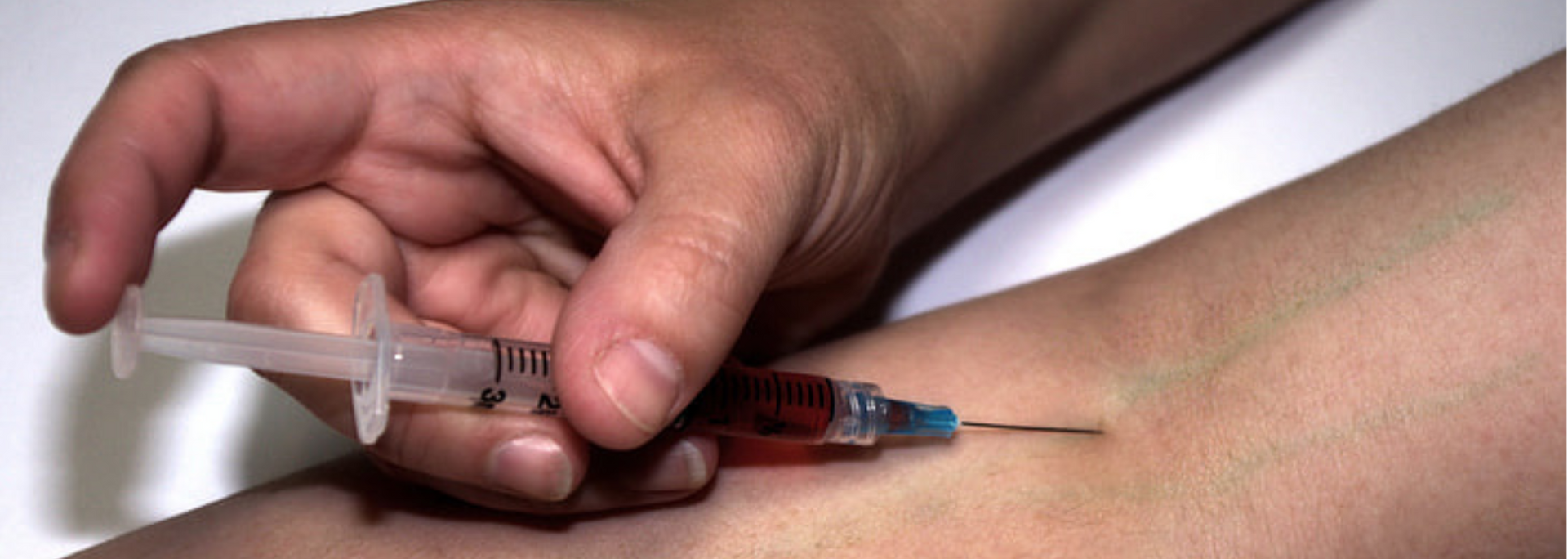 Picture of someone injecting with a syringe.