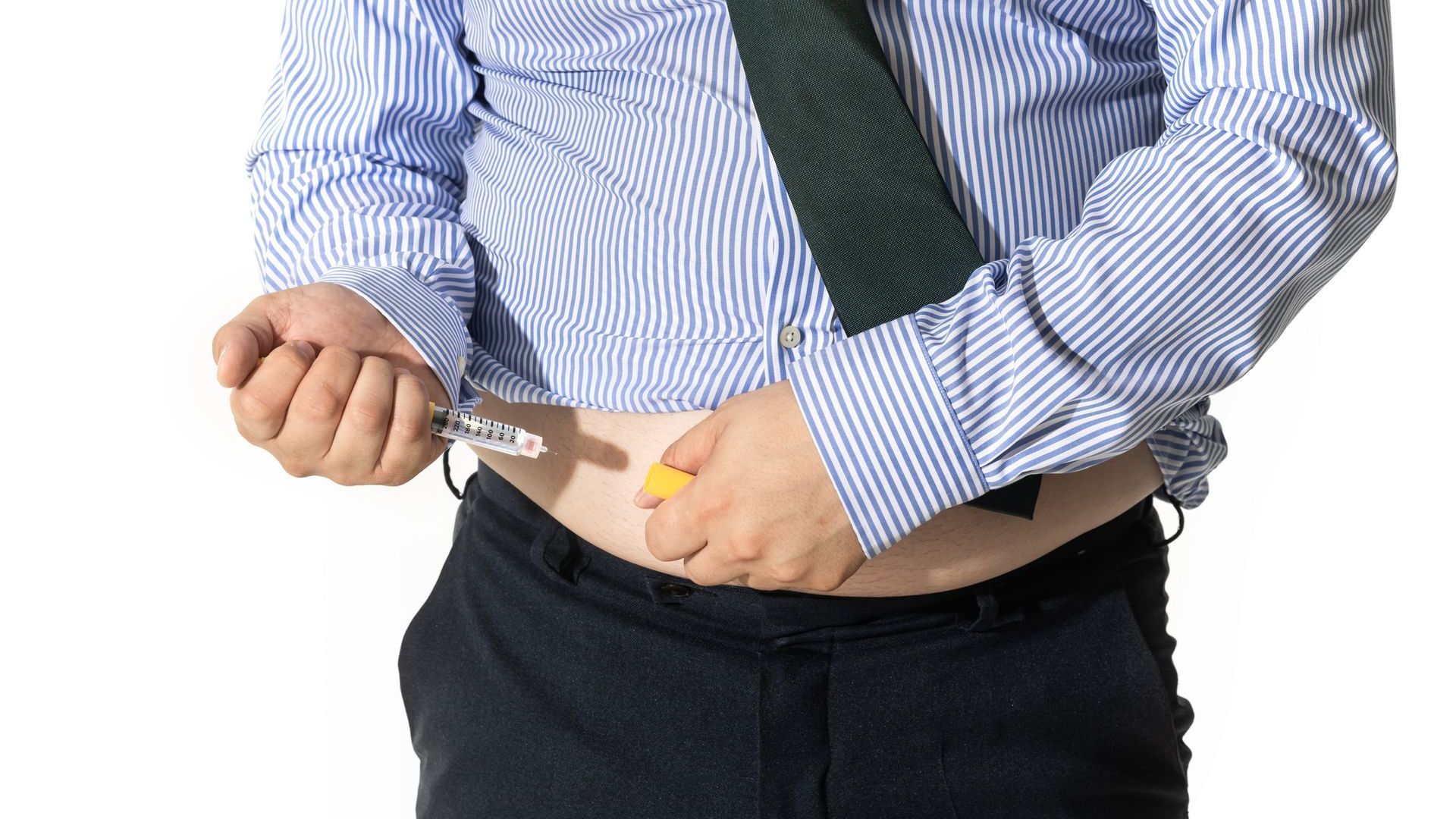 A man in a striped shirt and tie is injecting himself with an insulin pen.