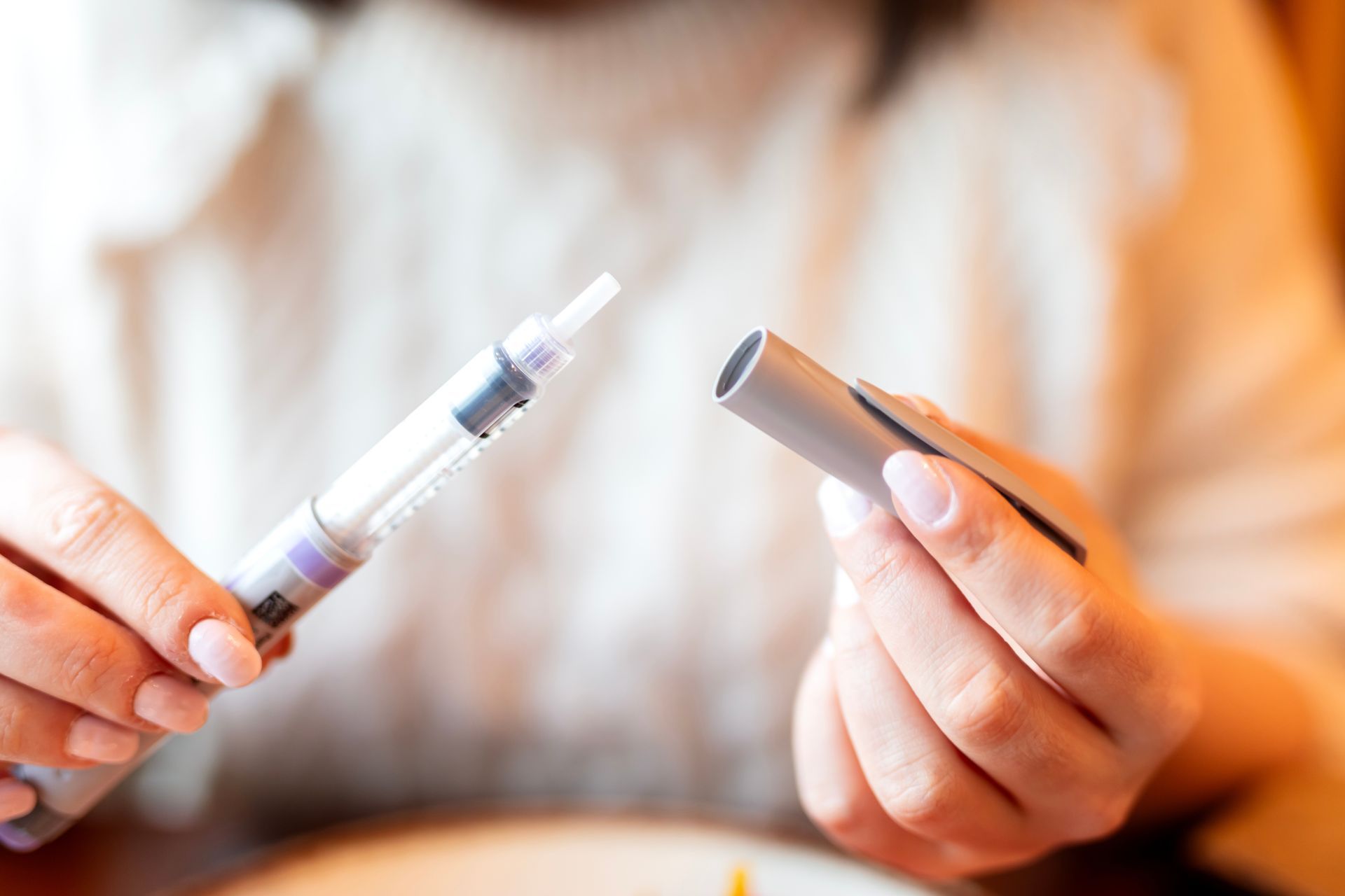 A woman is holding two electronic cigarettes in her hands.