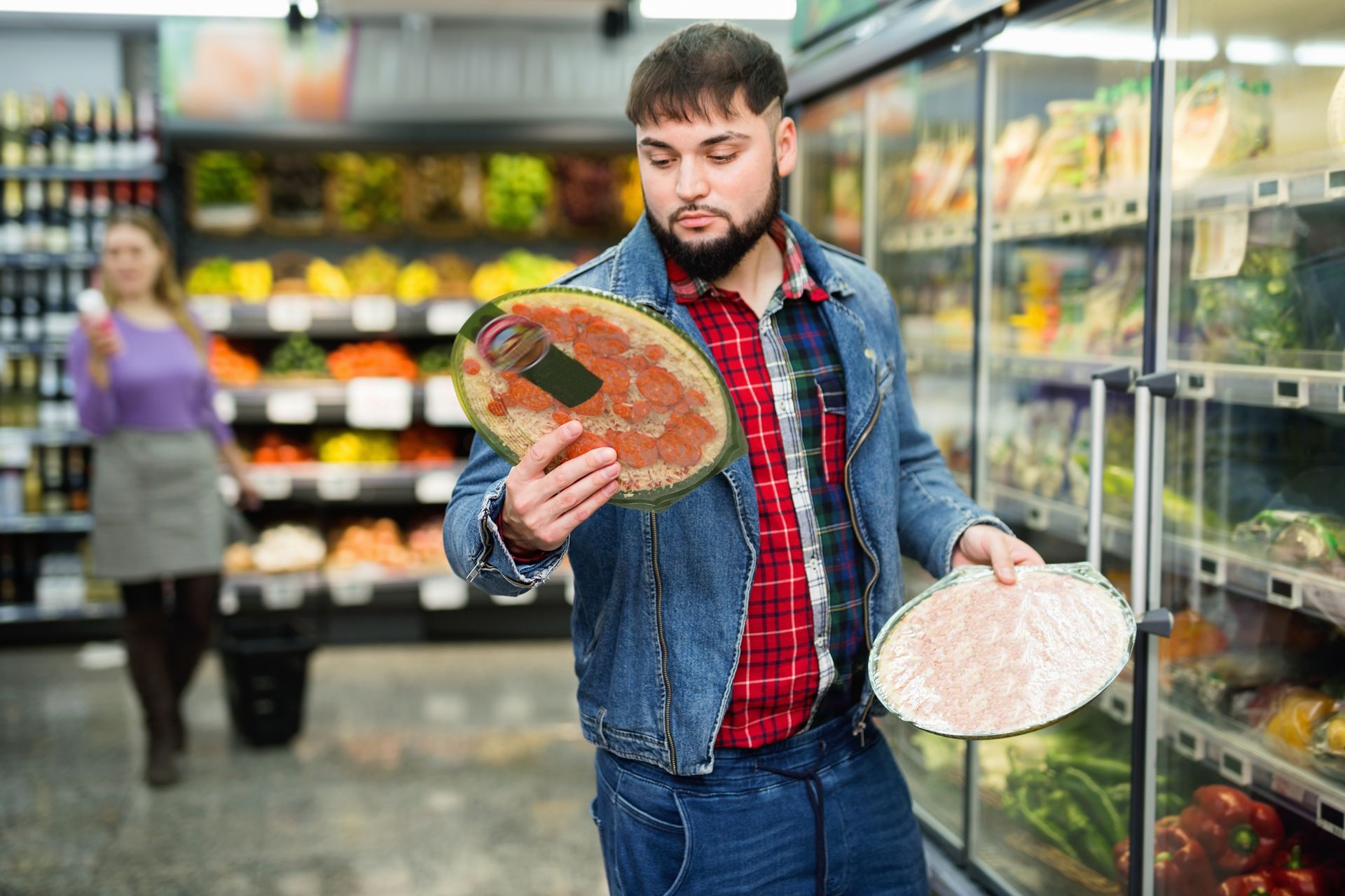 We all need to make wise choices.  A man in a supermarket is holding up a pizza.