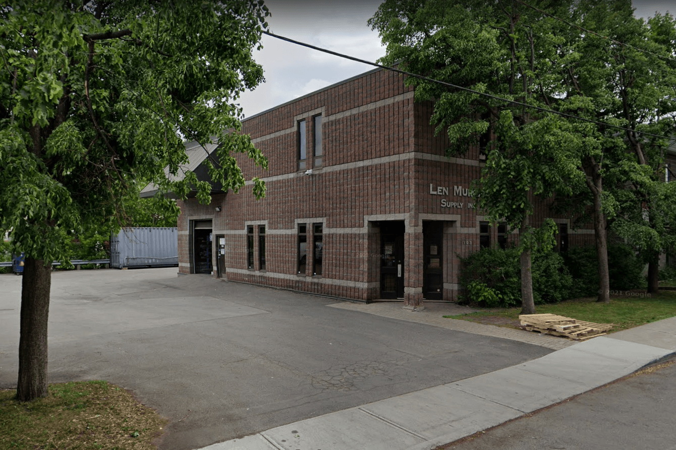 A large brick building with a parking lot in front of it.