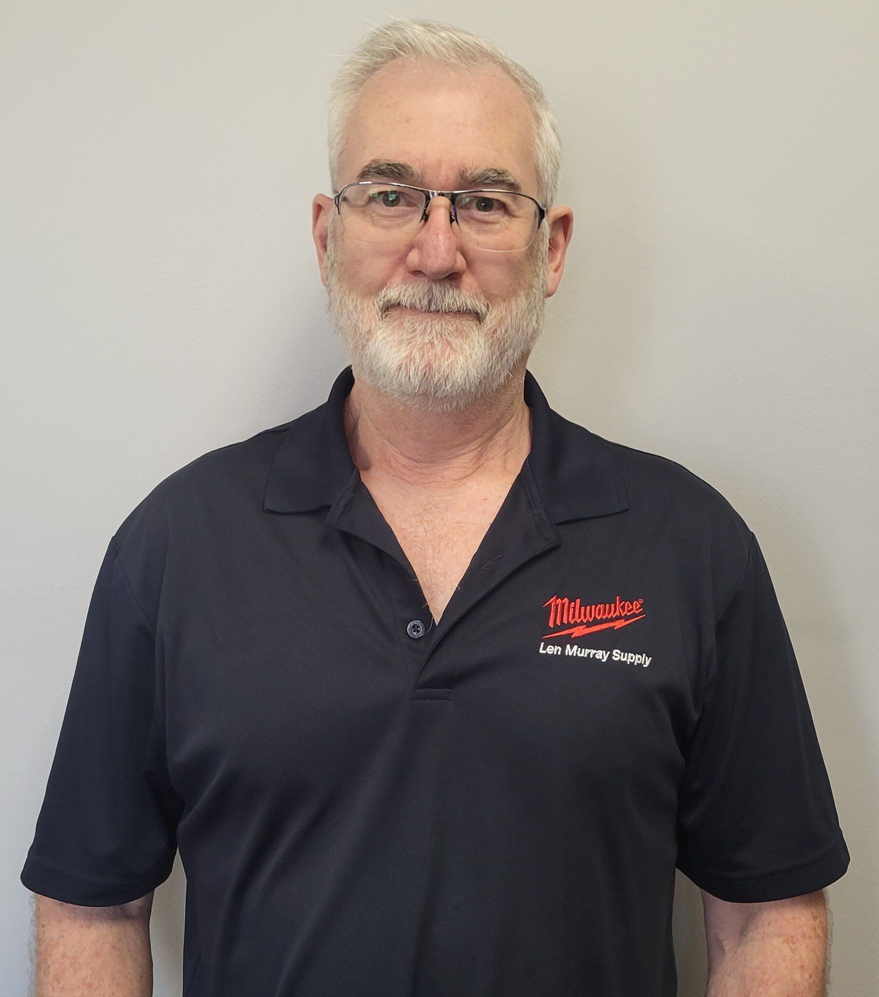 A man with a beard and glasses is wearing a black shirt that says milwaukee on it