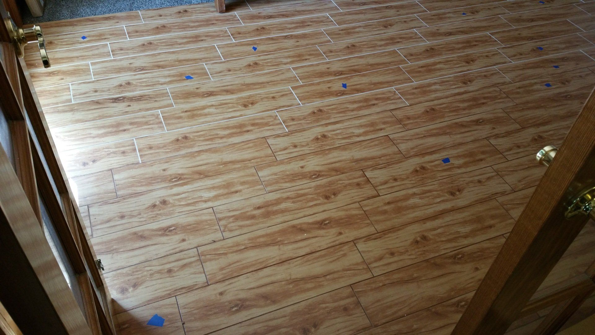 a wooden floor with blue tape on it