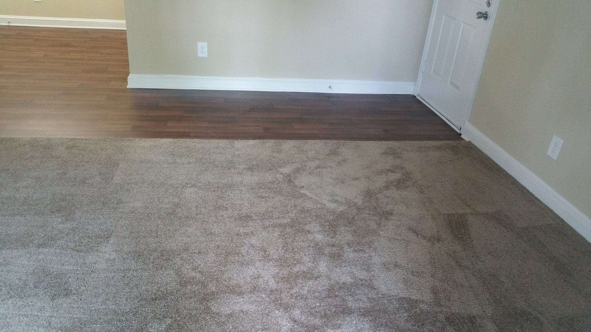a room with a wood floor and a carpeted floor
