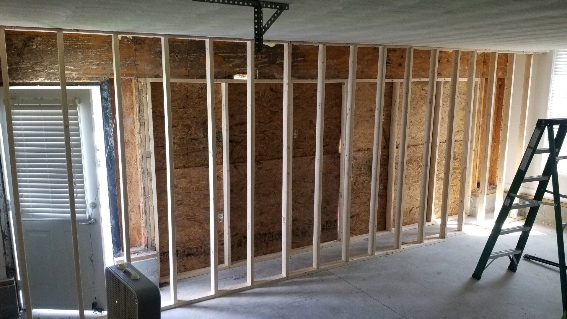 a ladder sits next to a wall that is being built