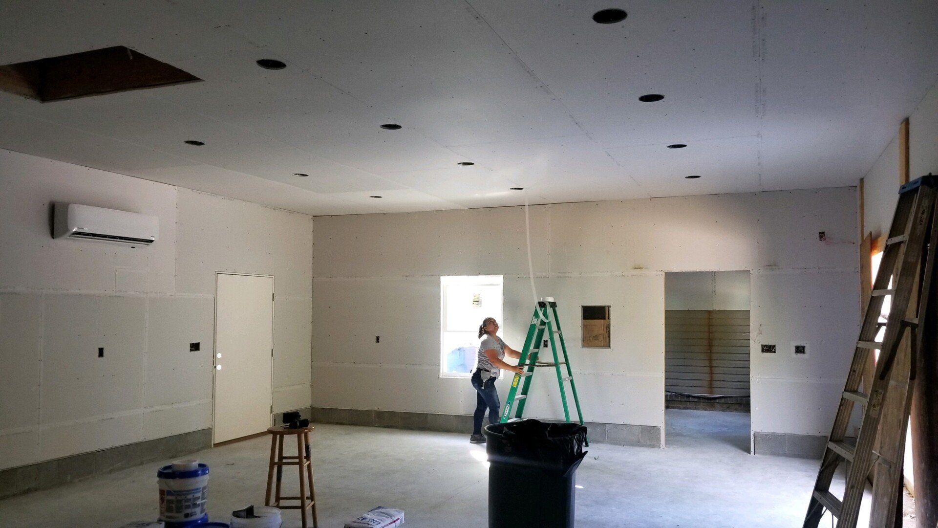 a woman standing in a room with a ladder