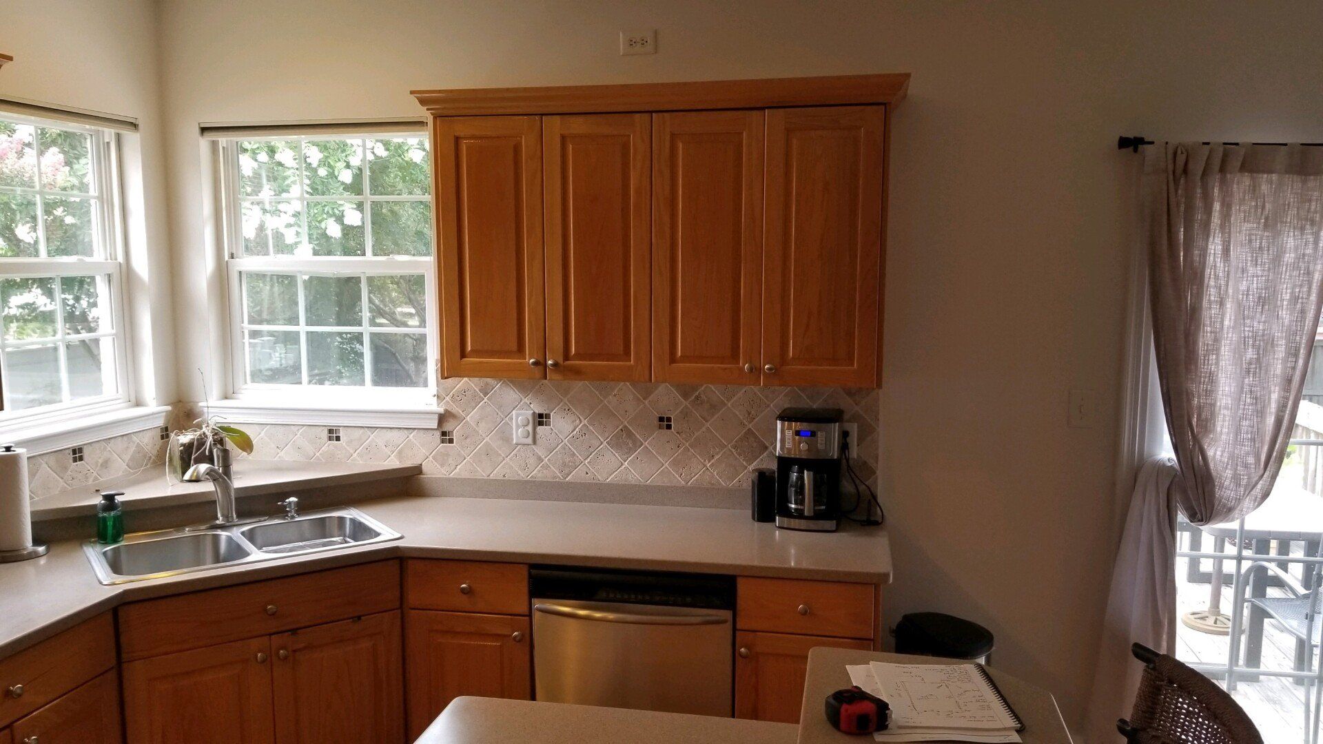 a kitchen with wooden cabinets and a stainless steel dishwasher