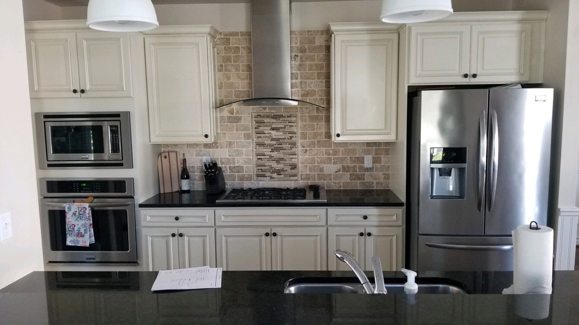 a kitchen with white cabinets and a stainless steel refrigerator