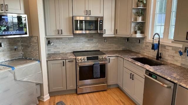 a kitchen with stainless steel appliances and granite counter tops .