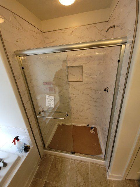 a bathroom with a sliding glass shower door and a bathtub .