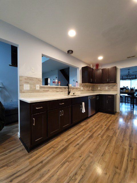 a kitchen with dark cabinets and a stainless steel dishwasher .