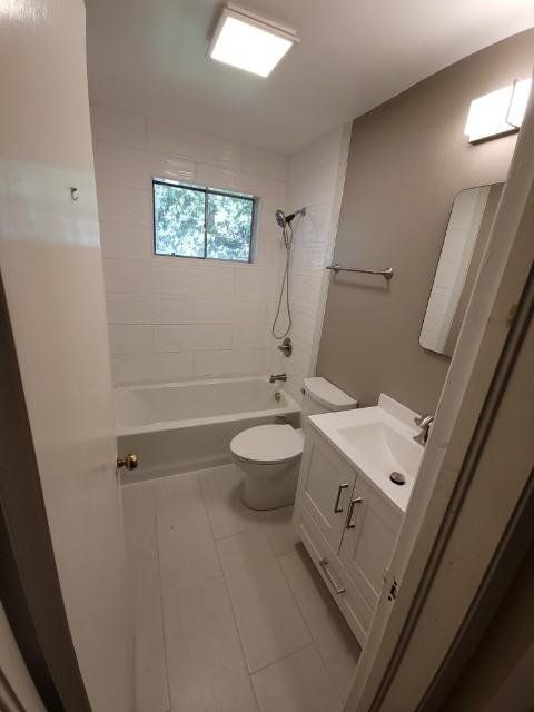 a bathroom with a toilet , sink , bathtub and window .