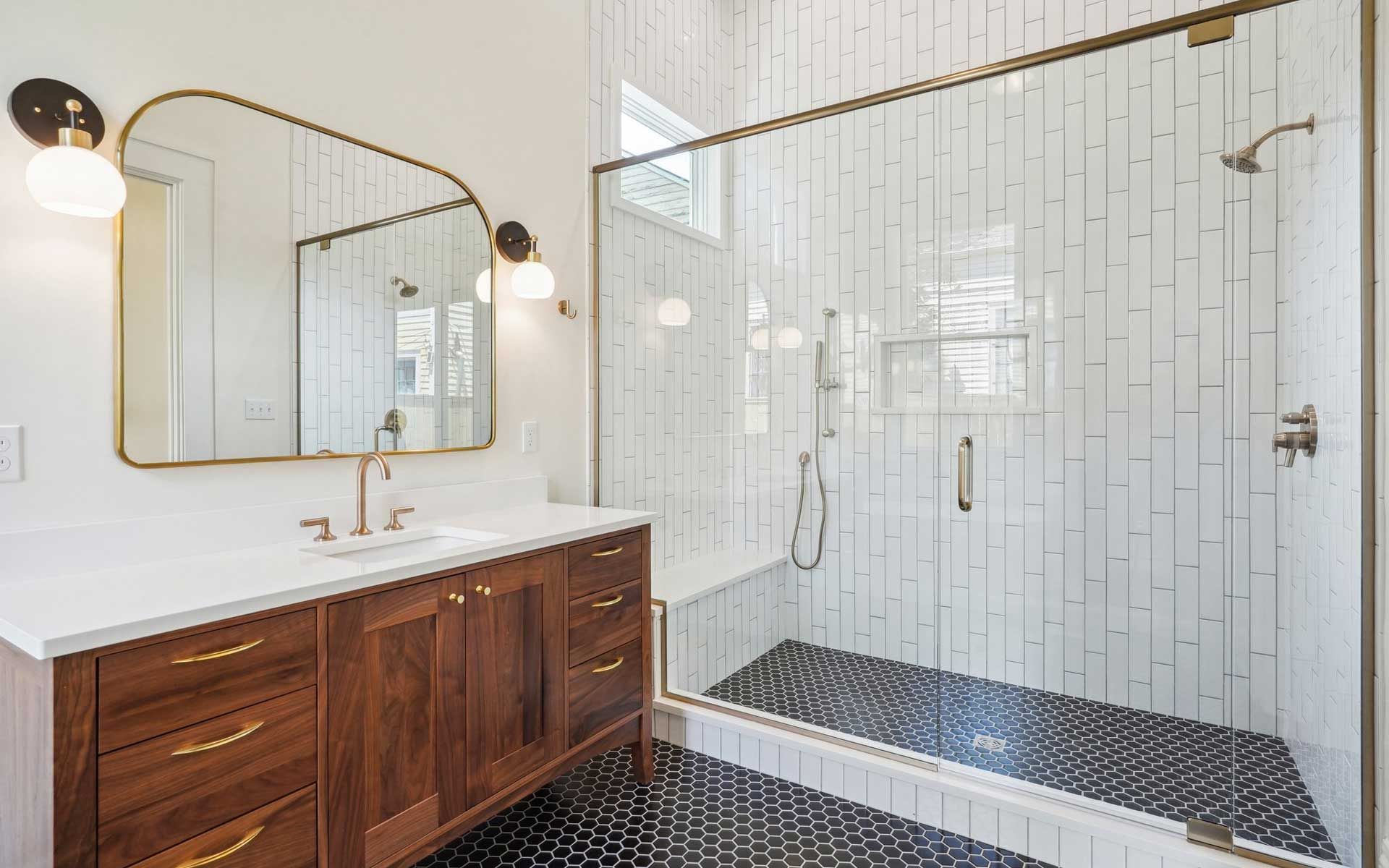 A bathroom with a walk in shower , sink and mirror.