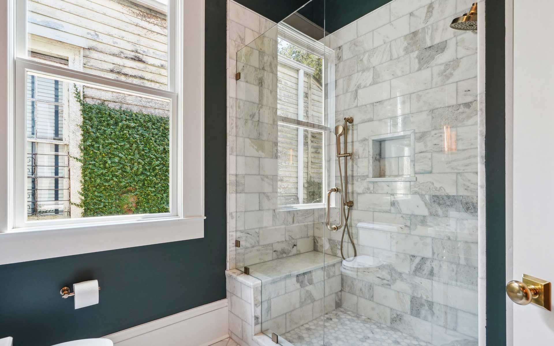 A bathroom with a walk in shower and a window.