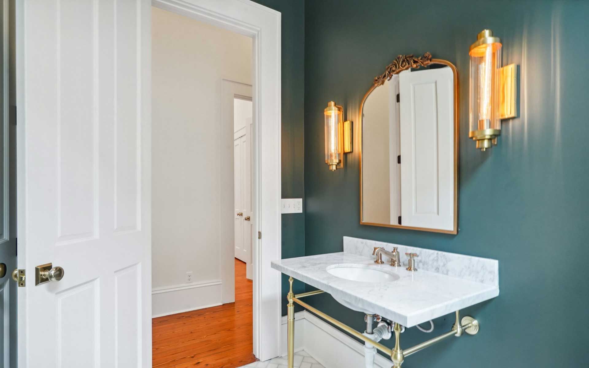 A bathroom with a sink , mirror and light fixtures.