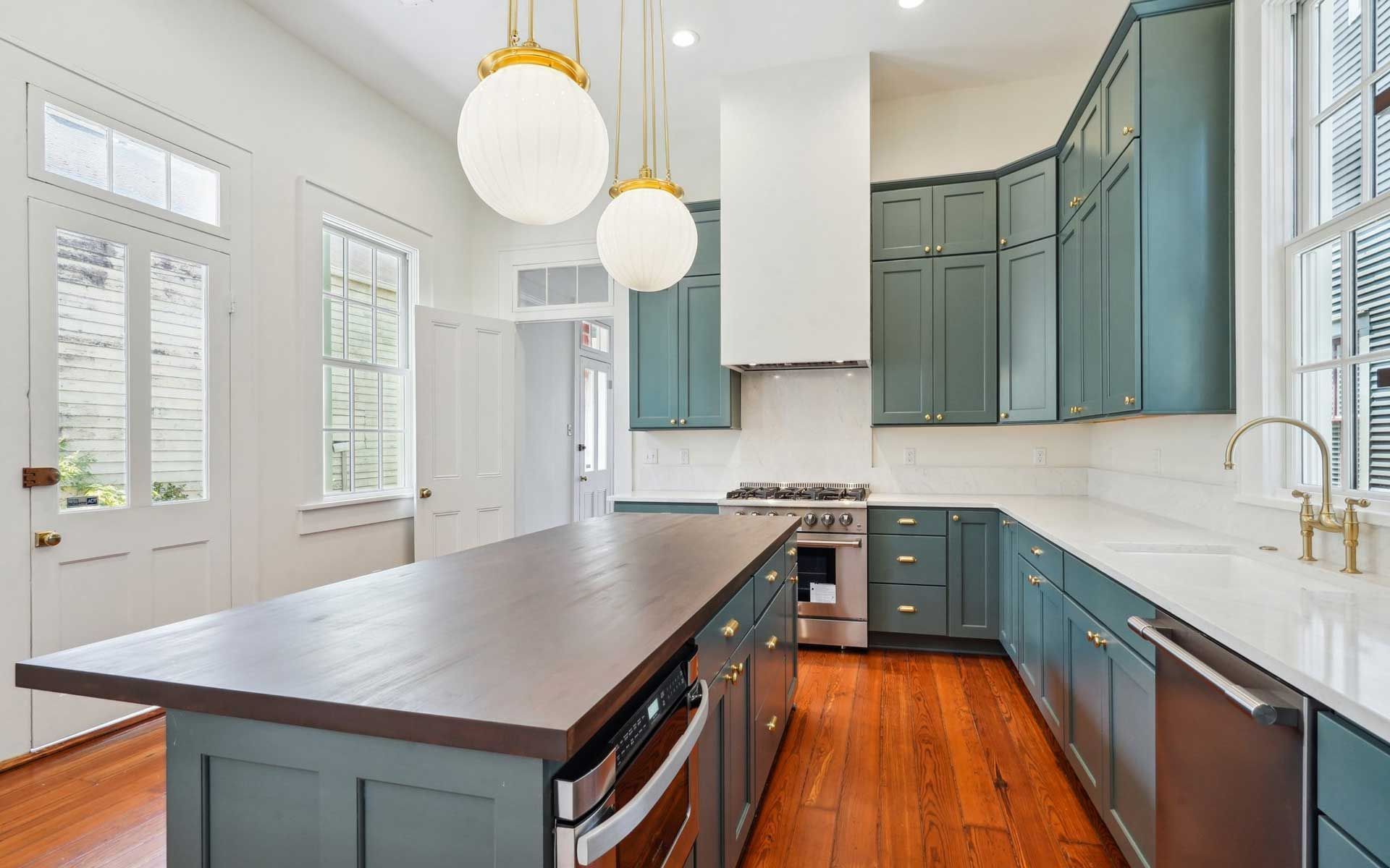 A kitchen with blue cabinets and a large island in the middle.