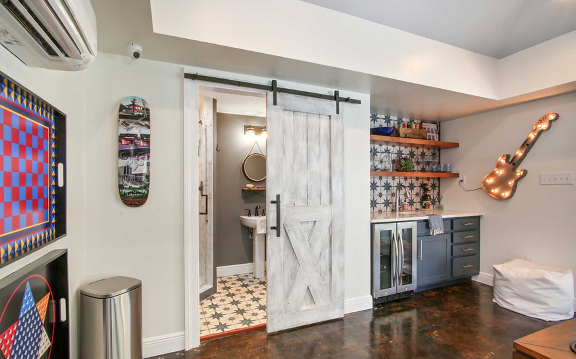 A living room with a sliding barn door leading to a bathroom.