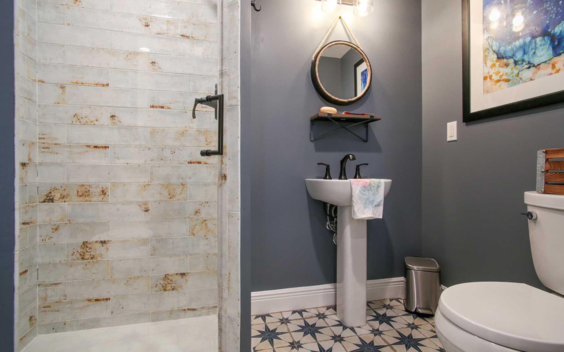 A bathroom with a toilet , sink and shower.