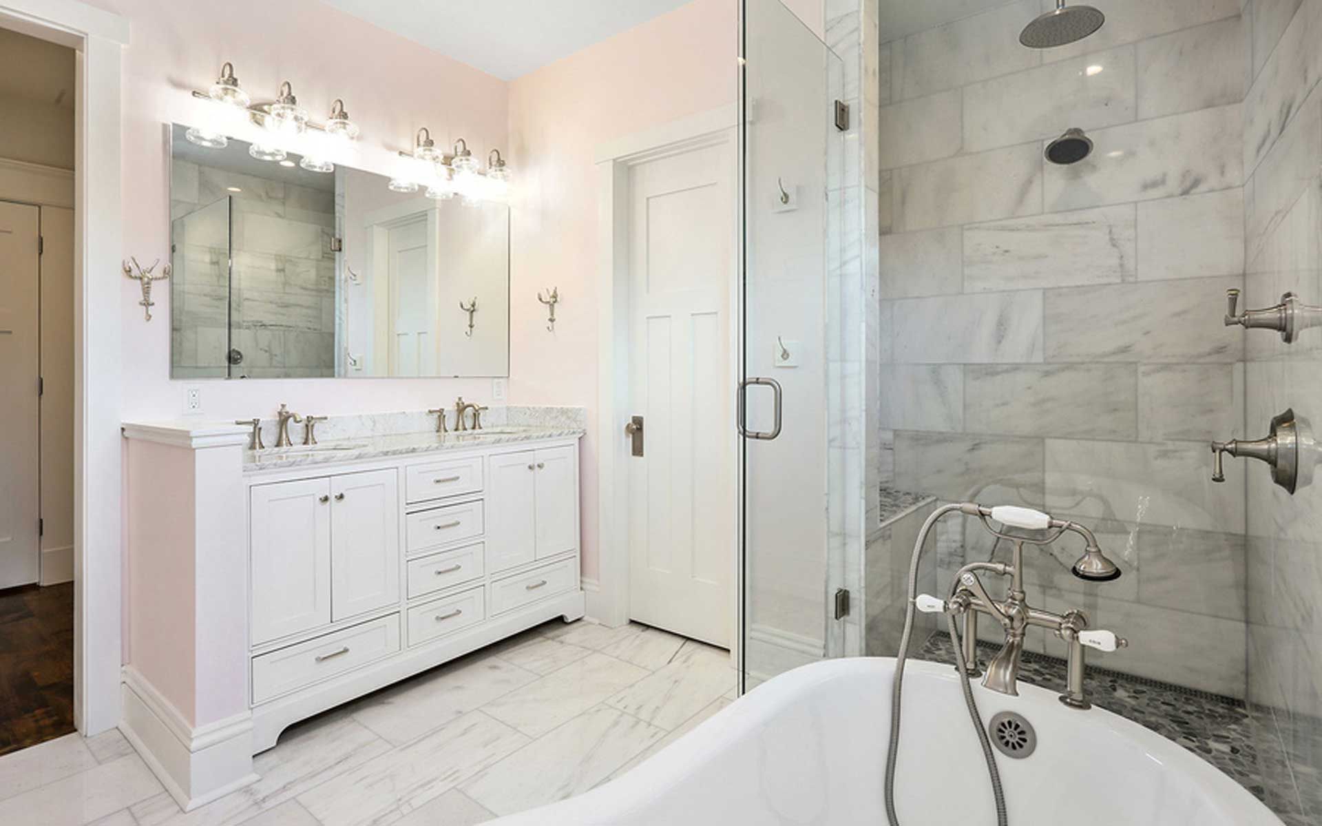 A bathroom with two sinks , a tub , a shower and a mirror.